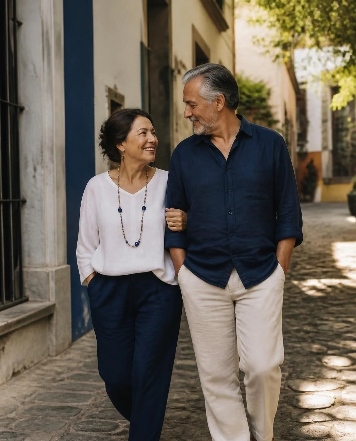Pareja de adultos caminando del brazo por una calle empedrada